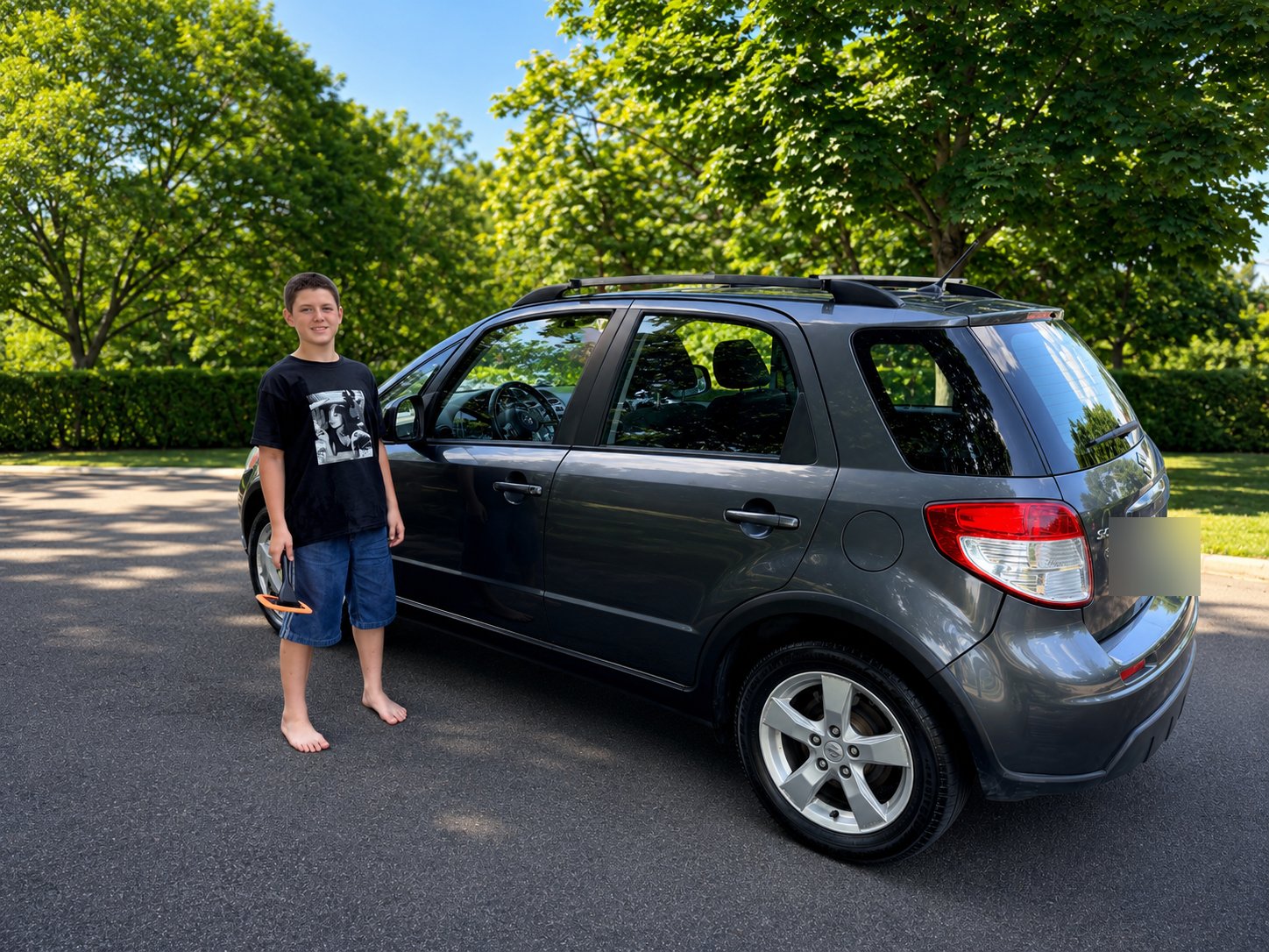 Émile devant une auto fraîchement lavée